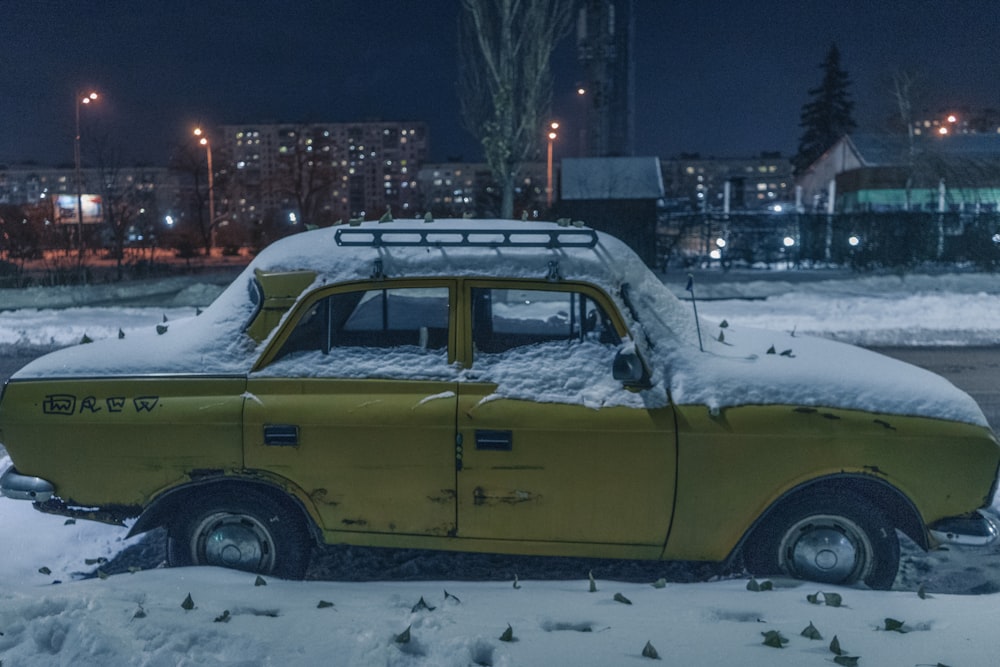 yellow sedan covered with snow