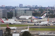 An aerial shot of a busy airport runway bustling with planes taking off and landing.
