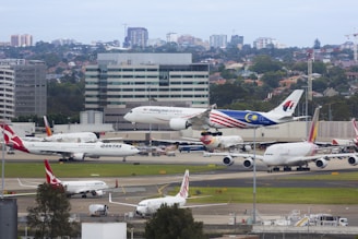 An aerial shot of a busy airport runway bustling with planes taking off and landing.