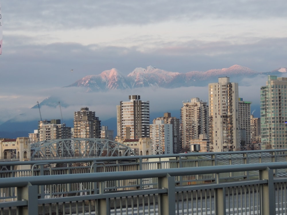 Stadt mit Hochhäusern, die Berge unter weißem und blauem Himmel betrachten