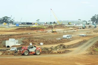 orange and white heavy equipment on muddy road during daytime