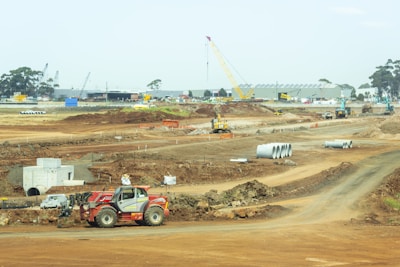 orange and white heavy equipment on muddy road during daytime