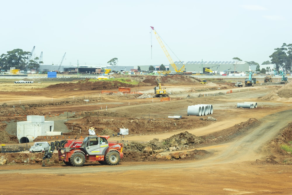 orange and white heavy equipment on muddy road during daytime