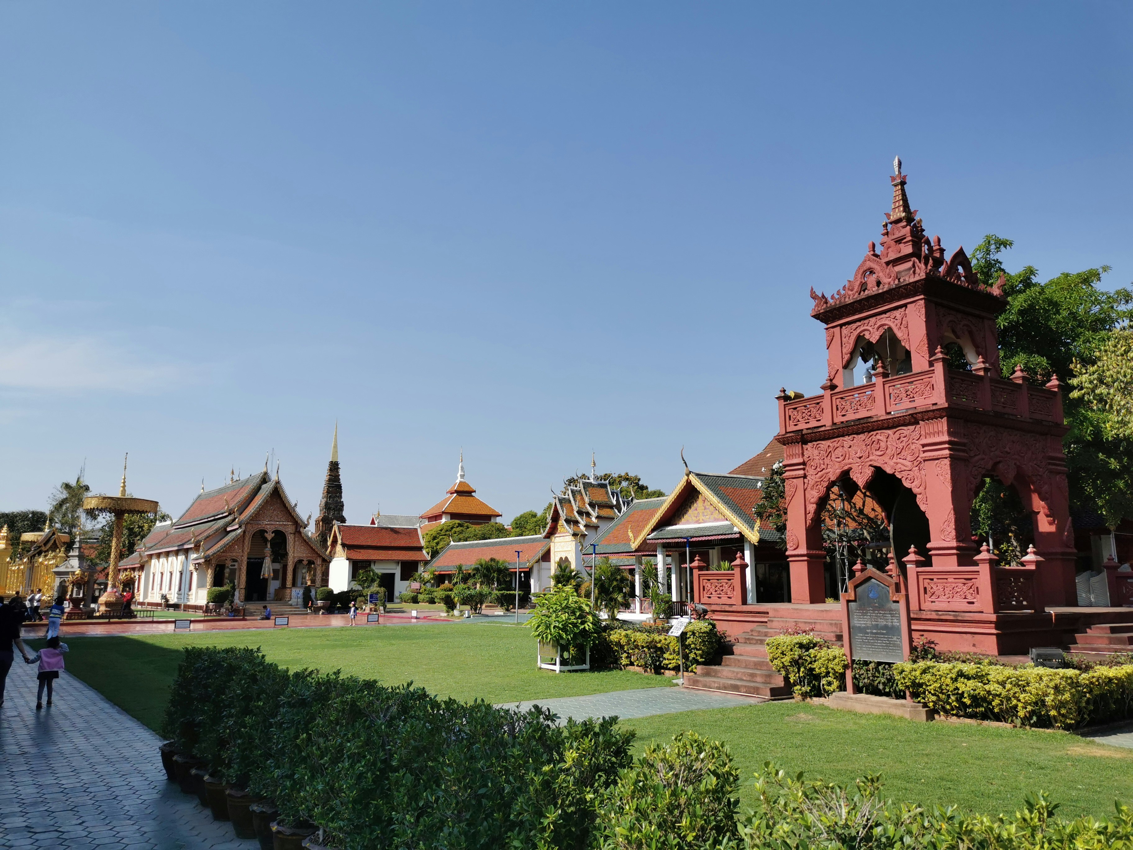 personnes marchant près du palais de Khao Wang en Thaïlande sous un ciel bleu et blanc
