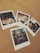 Five polaroid photographs are laid out on a tan surface. Each photo features groups of people at various social gatherings, seemingly enjoying themselves at restaurants or bars. The photos contain friends or family smiling, posing together, and sharing meals and drinks.