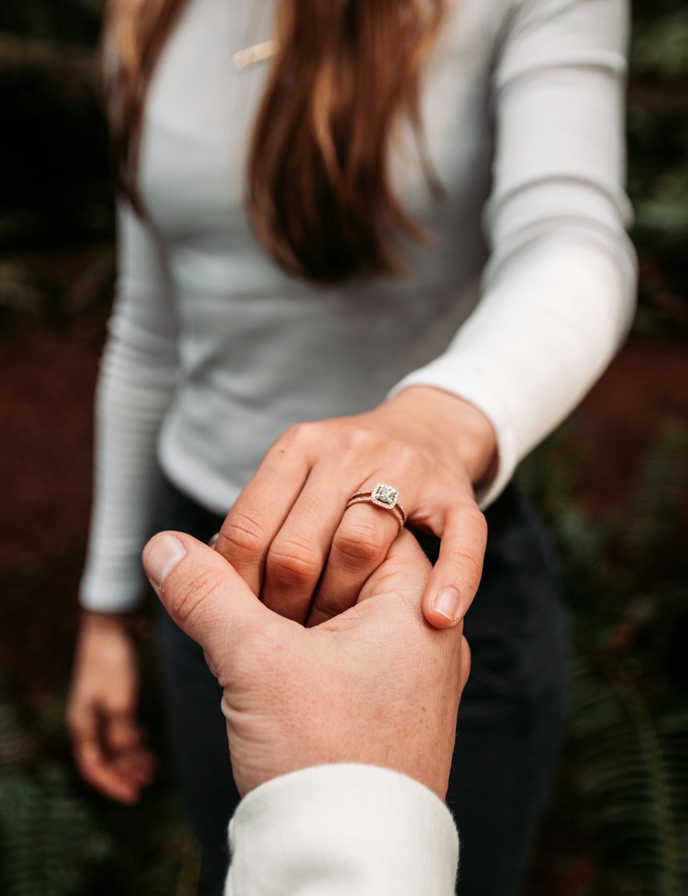 woman wearing ring holding hand of man