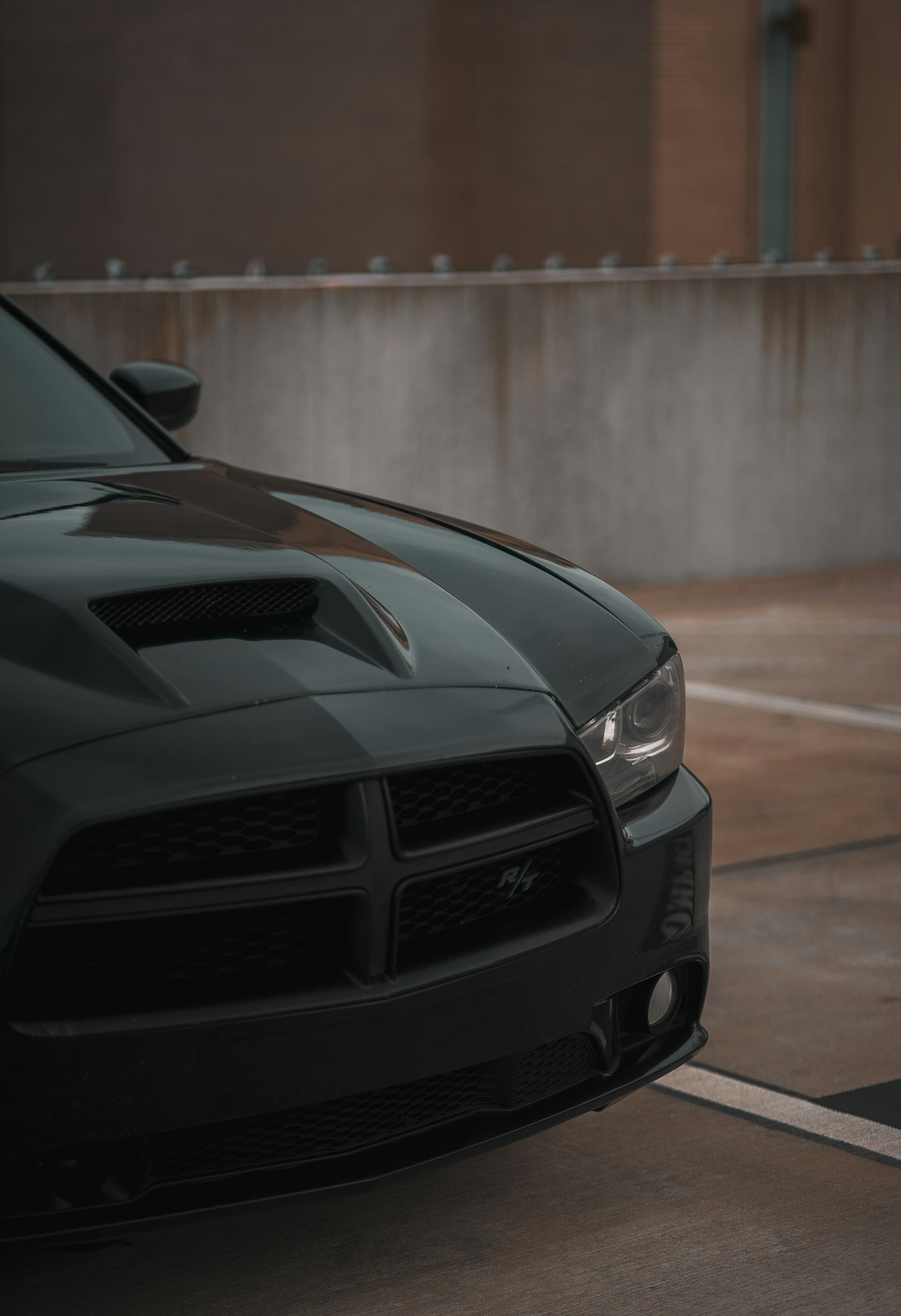 Sony a7 + Sony FE 85mm F1.8 sample photo. Black dodge charger parked photography