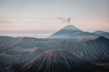 Dramatic volcanic landscape with clouds rolling over rugged peaks