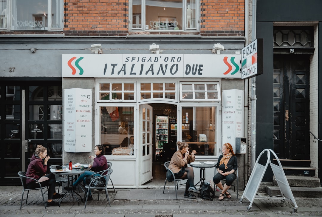 four people sitting outside Spigad'Oro Italino Due restaurant during daytime