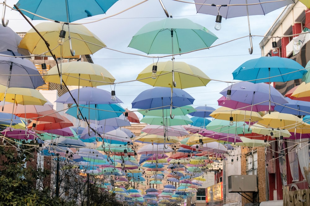 verschiedenfarbiger Regenschirm hängt in der Nähe von Gebäuden