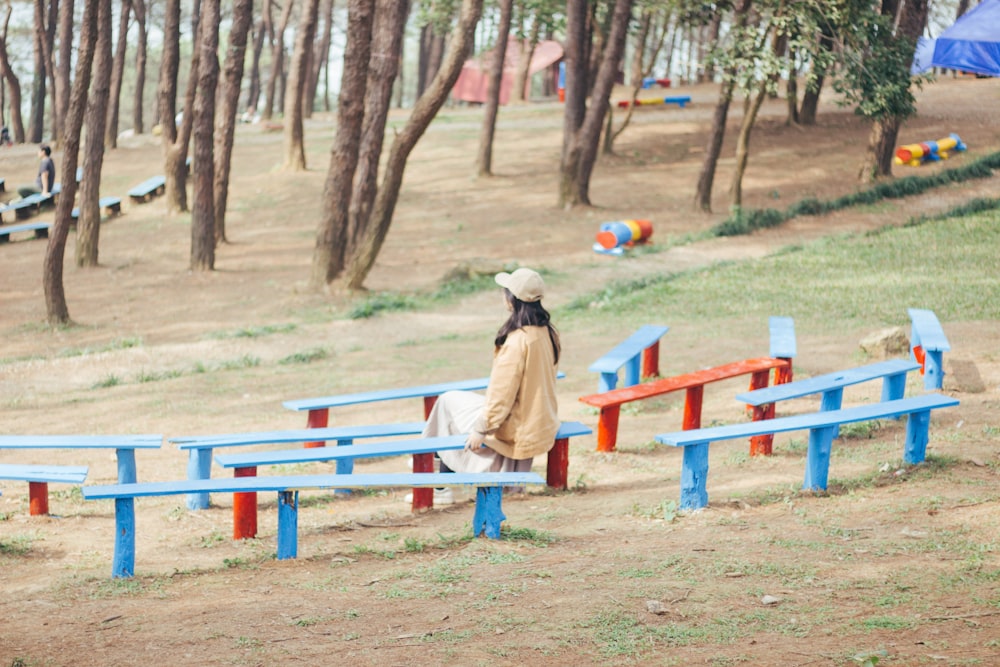 Femme portant une veste marron assise sur un banc extérieur dans un parc