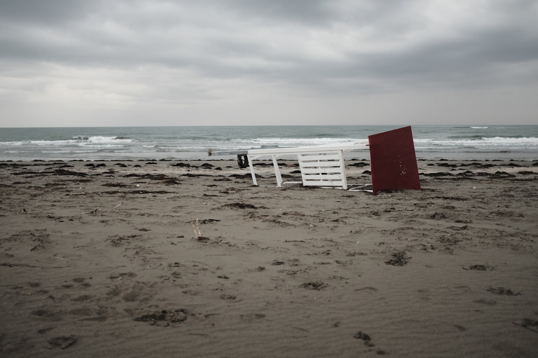 white wooden table near seashore under white and gray sky