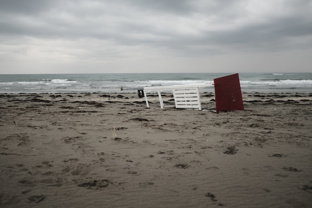 Mesa de madera blanca cerca de la orilla del mar bajo el cielo blanco y gris