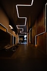a dimly lit hallway with benches and a painting on the wall