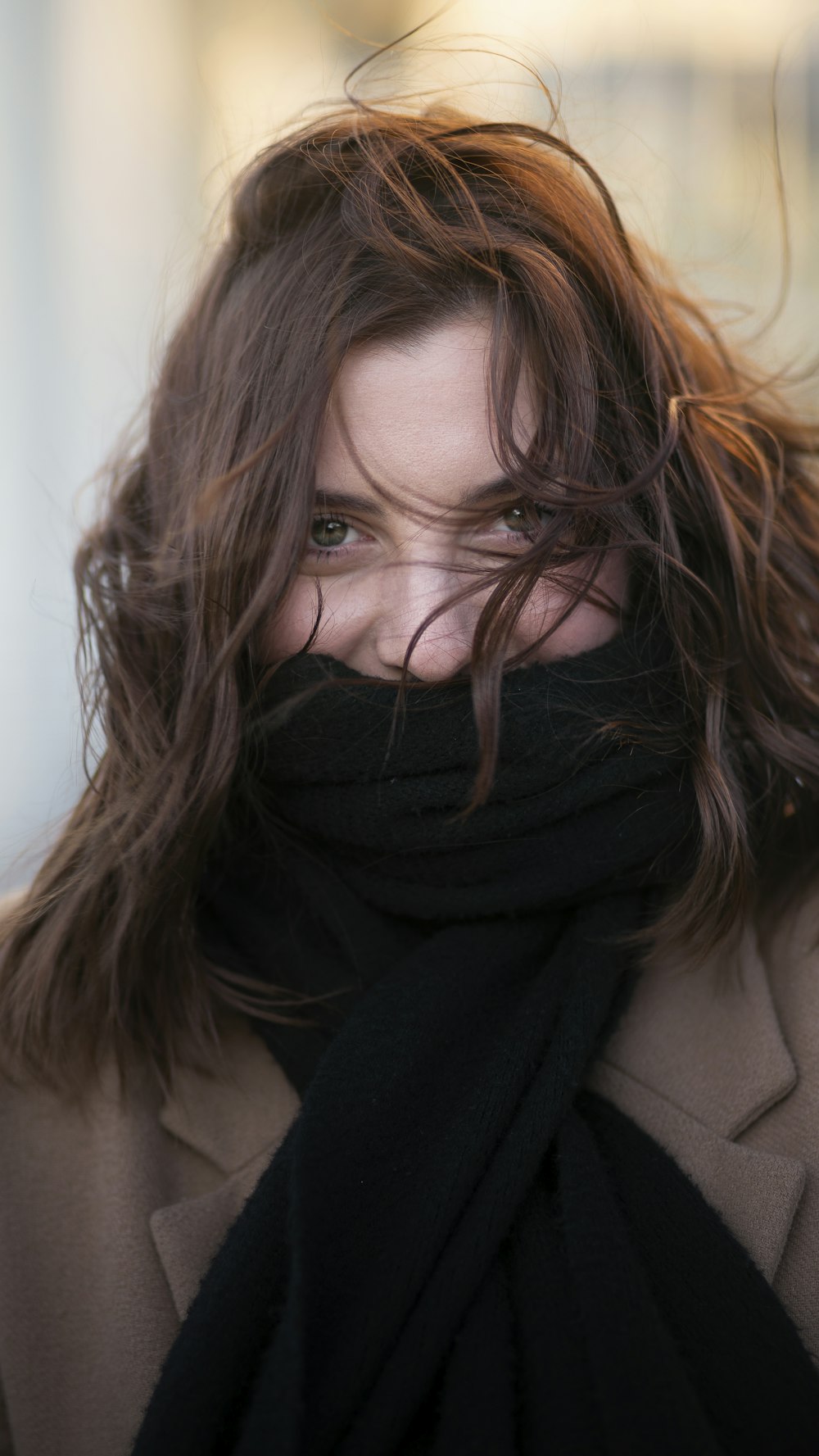 woman smiling and looking at the camera with scarf covering her mouth