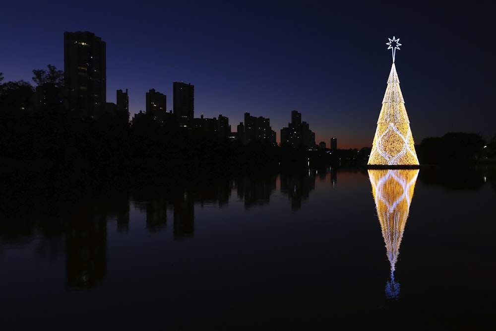 reflection of Christmas tree on body of water