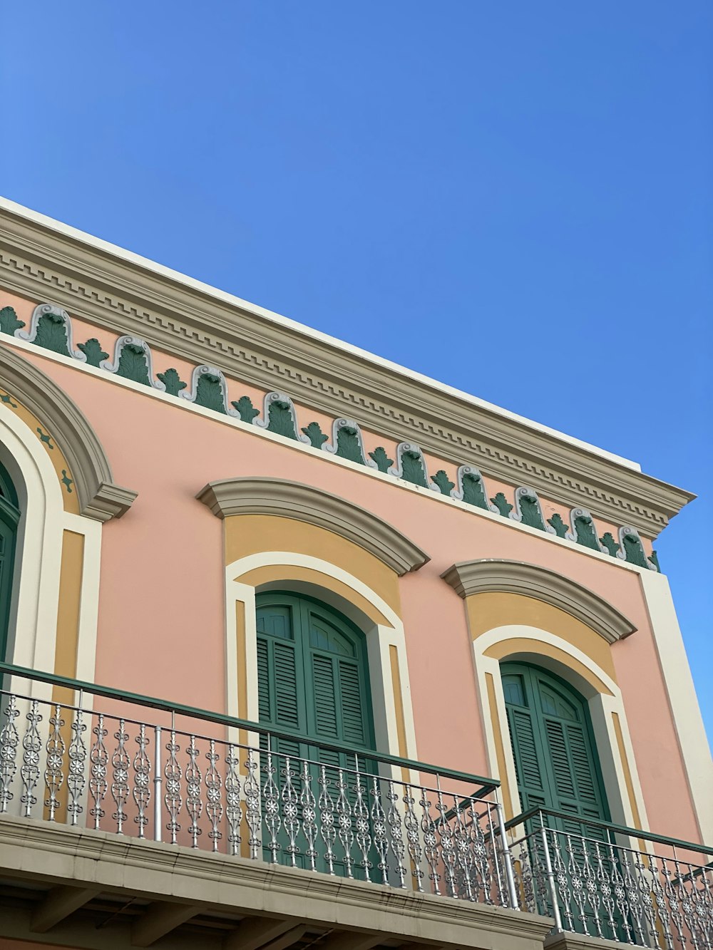 Edificio de hormigón rosa y verde bajo cielo azul