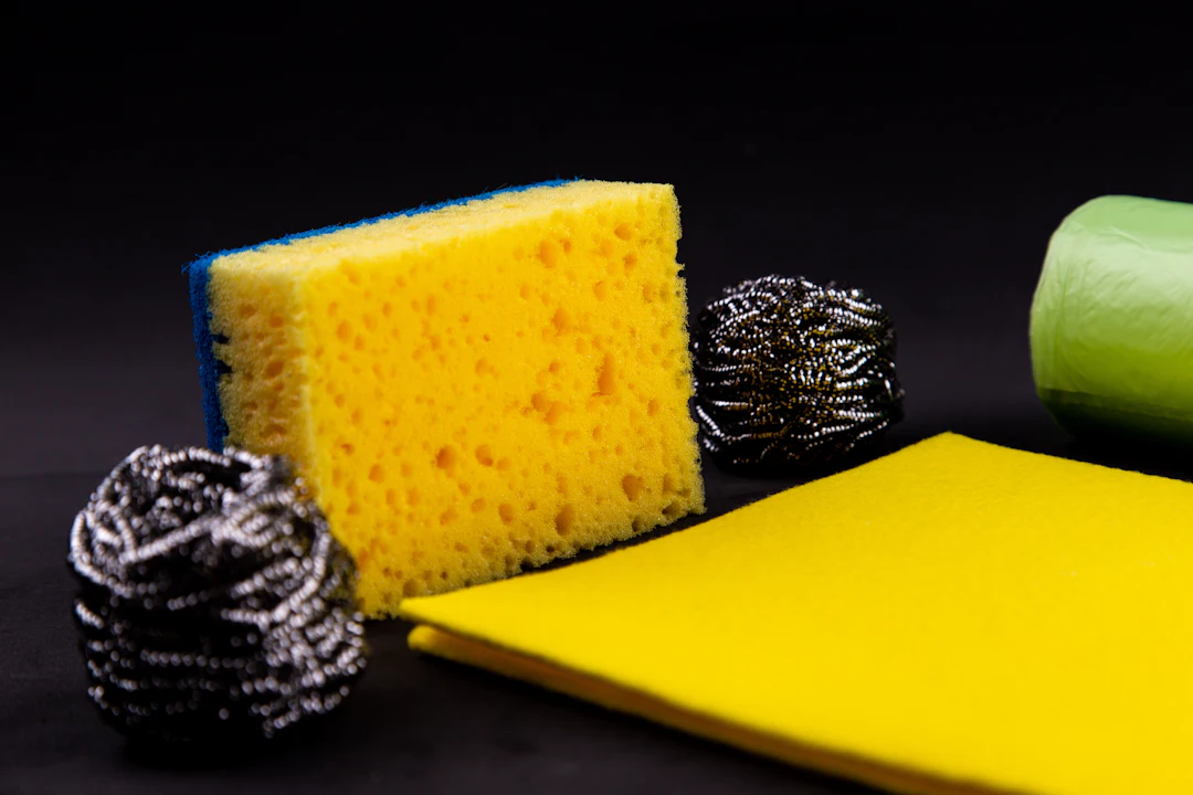 Yellow sponge, cloth and steel scrubbers on a black background