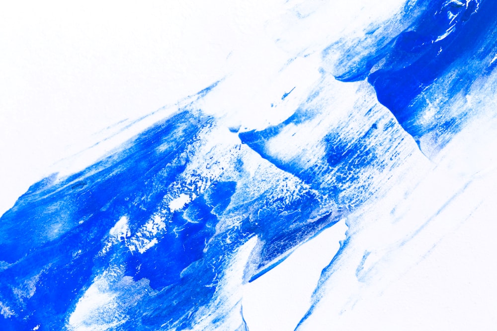 Una pintura azul y blanca de una montaña cubierta de nieve