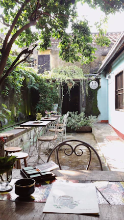 Cozy outdoor seating area of Hernán Café Restaurant with lush greenery in Santa Cruz