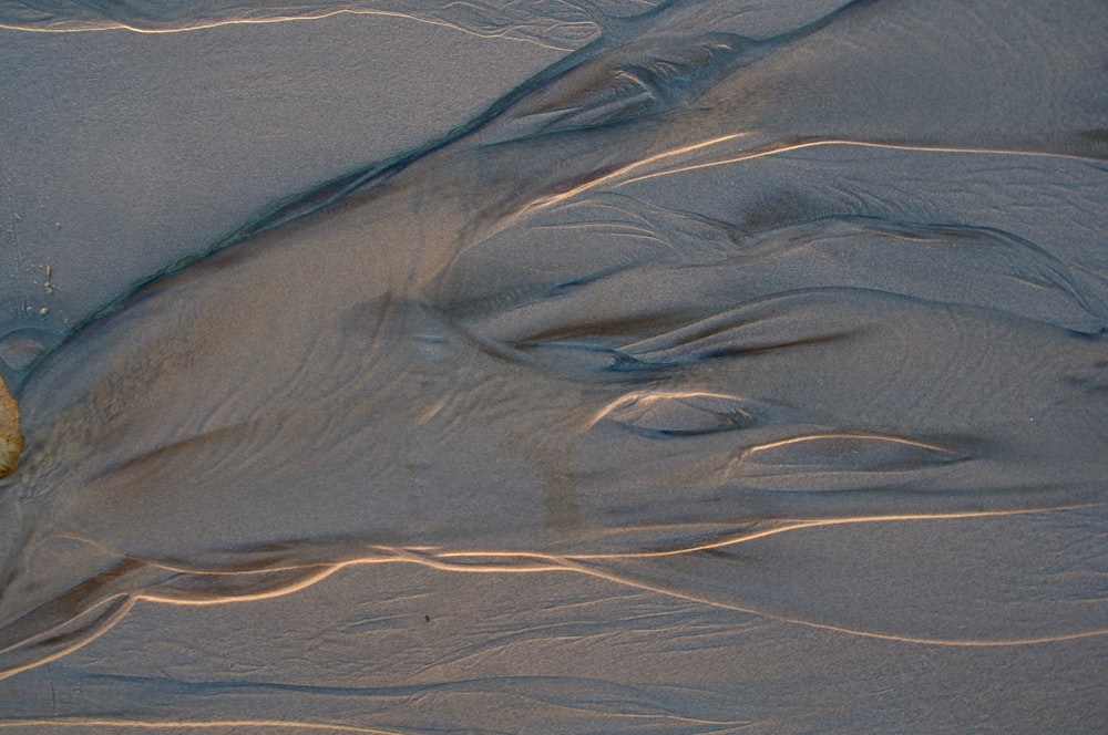 a large rock sitting on top of a sandy beach