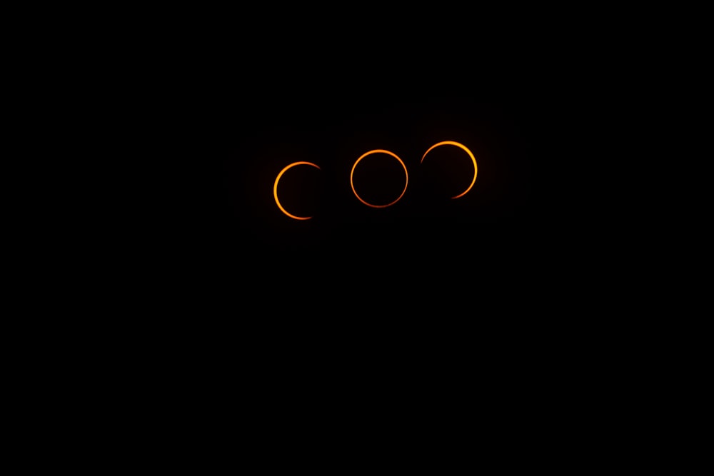 Un fondo negro con tres eclipses en el cielo