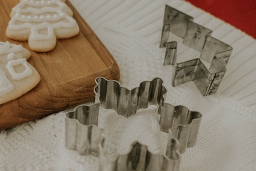 Close-up of colorful sugar cookies decorated with festive holiday icing and sprinkles on a rustic wooden table.