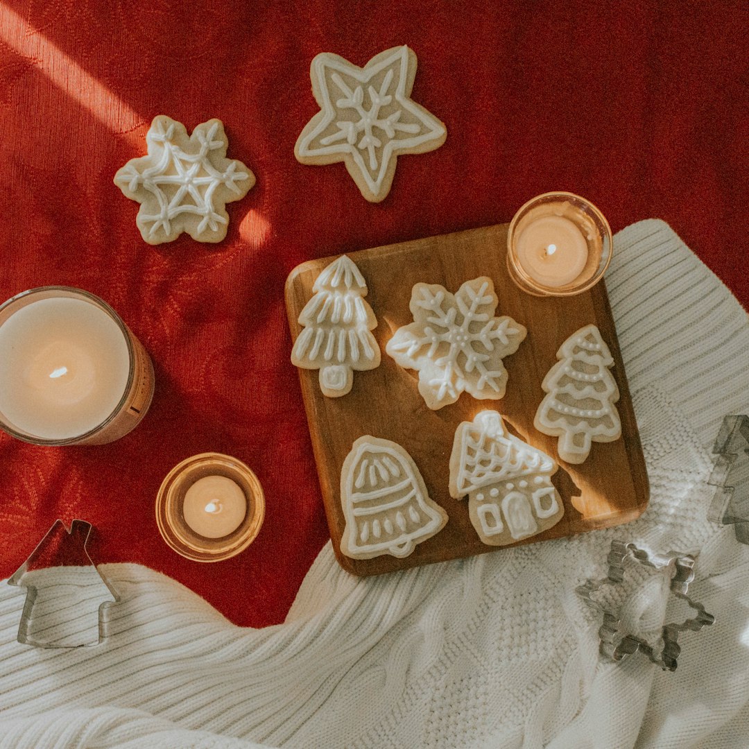 Christmas design cookies on red and white garment and three lighted candles