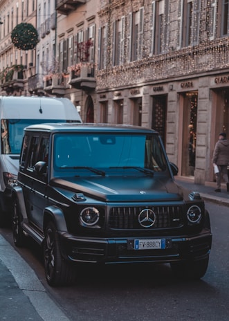 Mercedes SUV parked on a city street at night with golden streetlights illuminating it