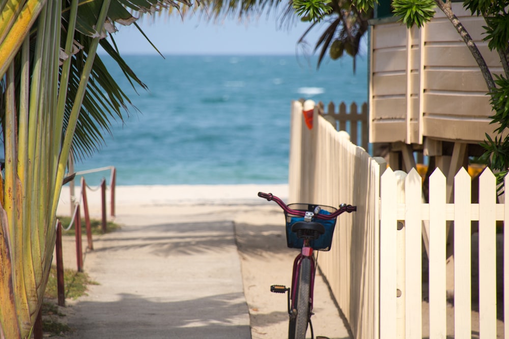 Parkings à vélos près de la clôture blanche en face de la plage