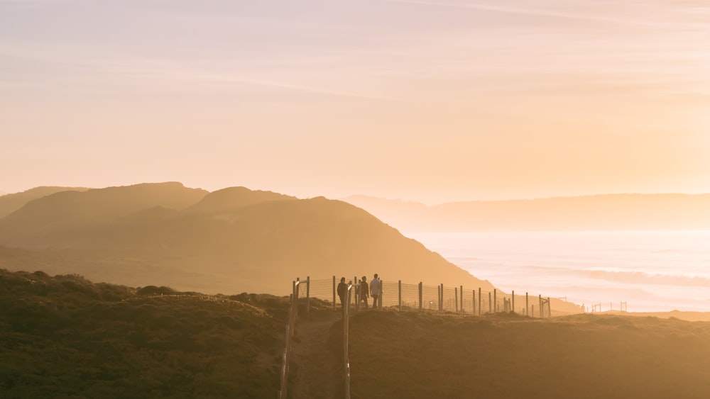 people on a mountain top during golden hour