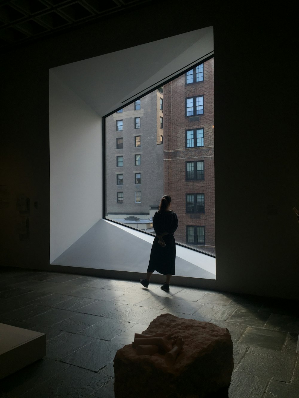 mulher em pé na frente do edifício de vidro da janela
