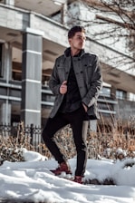 A man confidently walking through a snowy city street wearing a stylish, insulated winter jacket from wearupps.