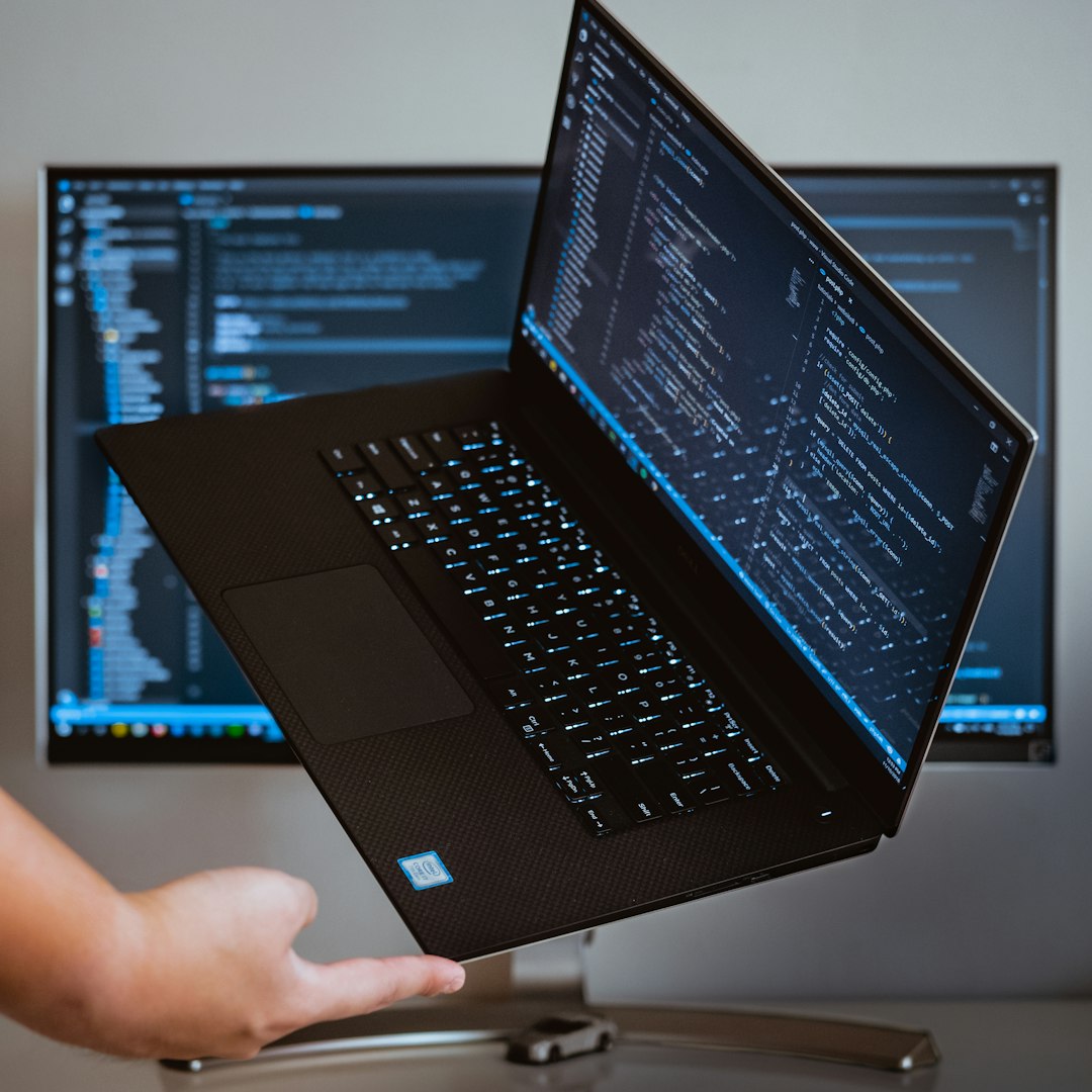 A turned-on laptop showing code, the custom app route where a spreadsheet becomes software the business owns