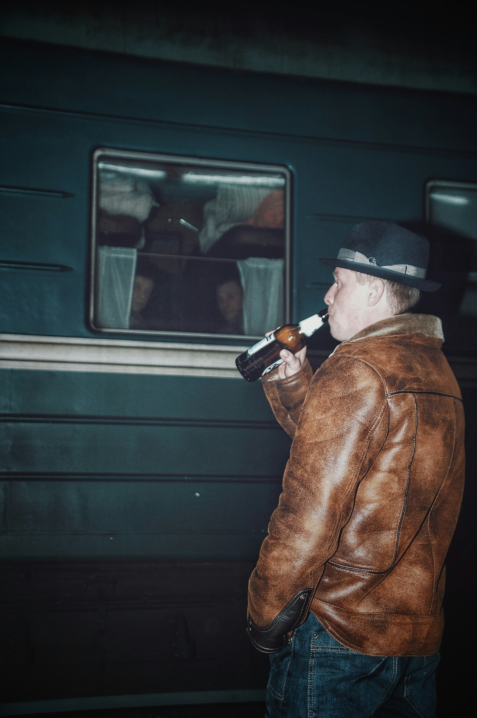 man wearing brown leather jacket drinking beer