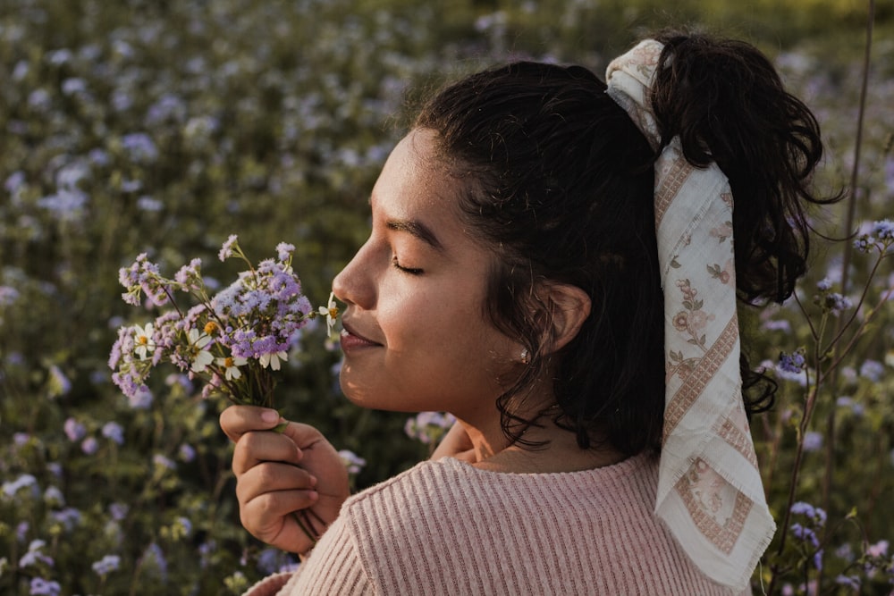 woman holding purple flower