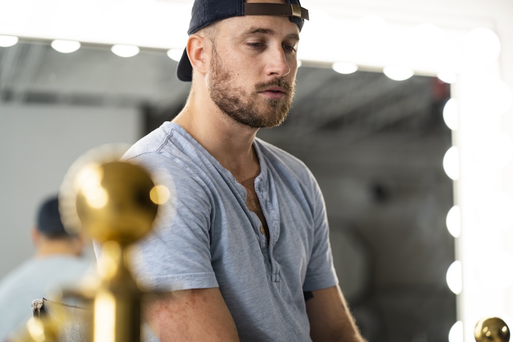man wearing gray cap-sleeved shirt