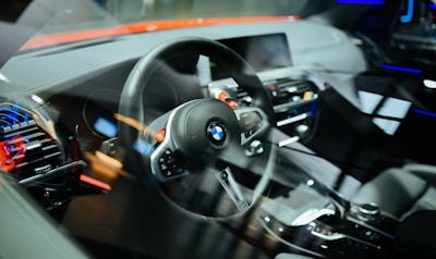 Close-up of hands on a steering wheel inside a modern car with clear dashboard controls.