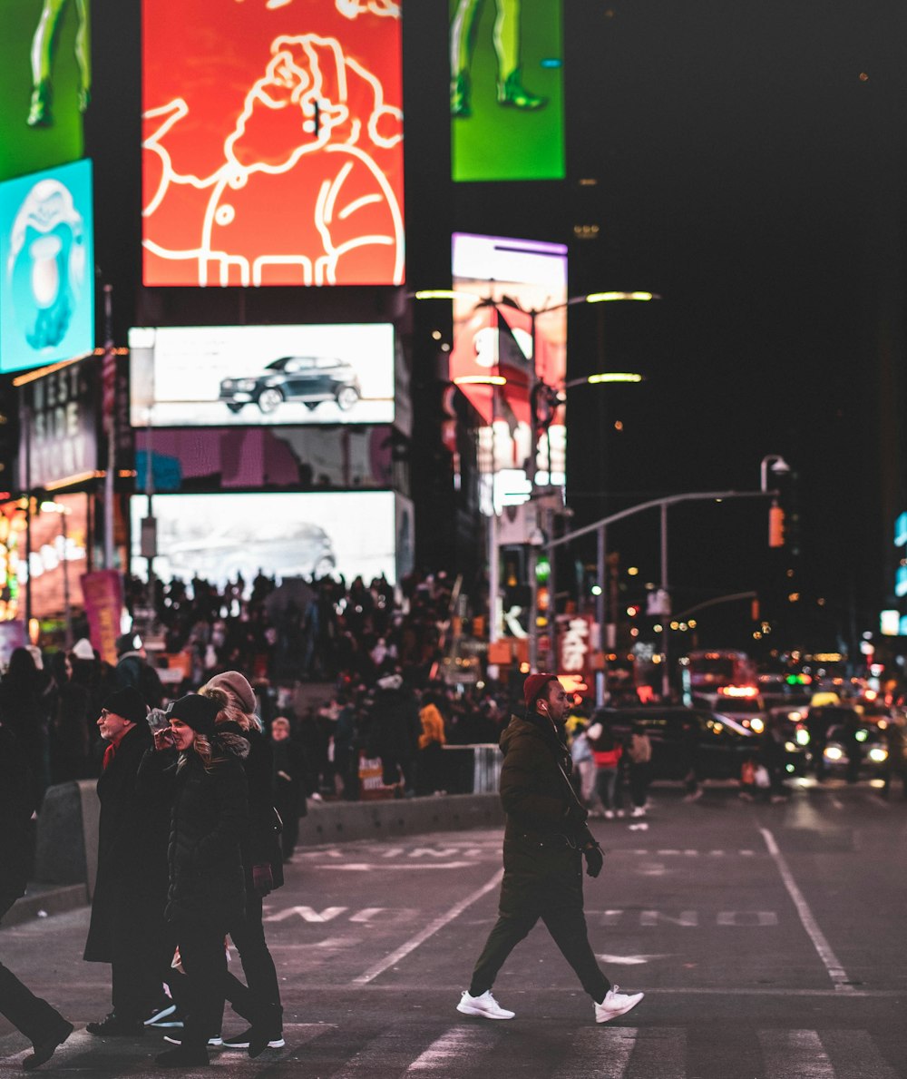 people crossing on road during nighttime