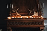 A rustic fireplace mantle decorated with seasonal garlands and cozy knit throws.