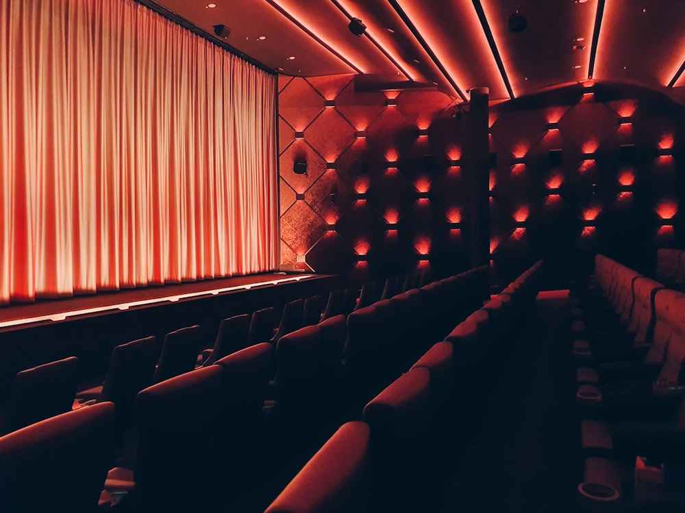 an empty theater with red curtains and seats