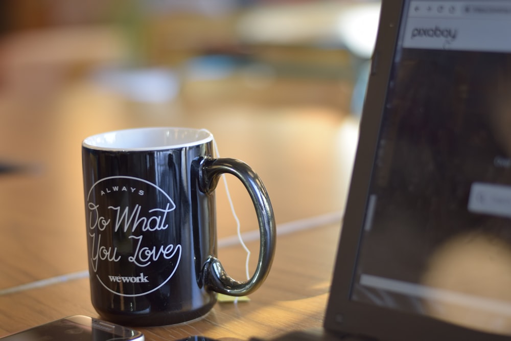 black ceramic mug on brown surface