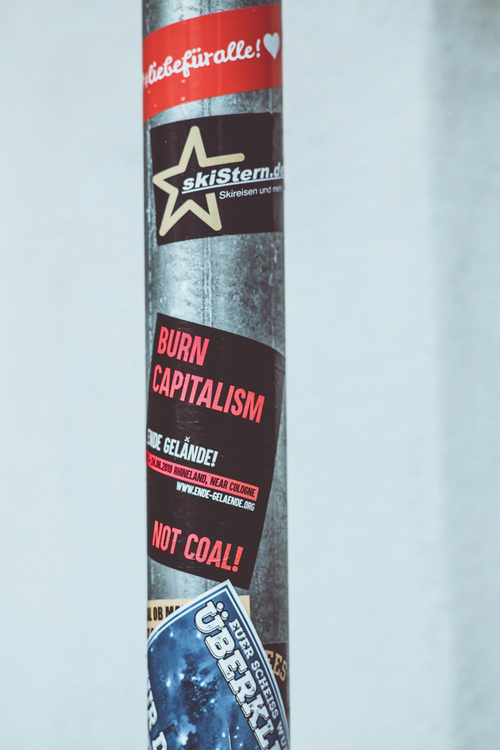 stickers on a gray metal pole