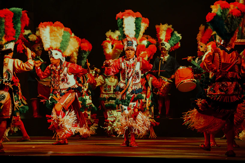Colorful dancers in traditional Ayacucho costumes performing under bright festival lights.
