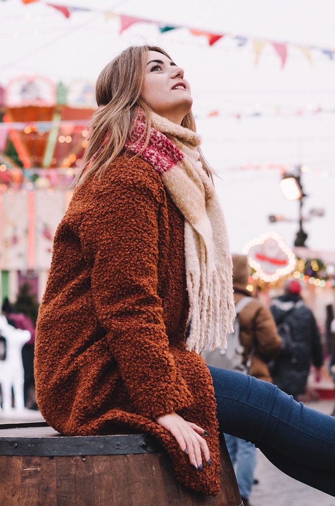 woman sitting on concrete bench looking up