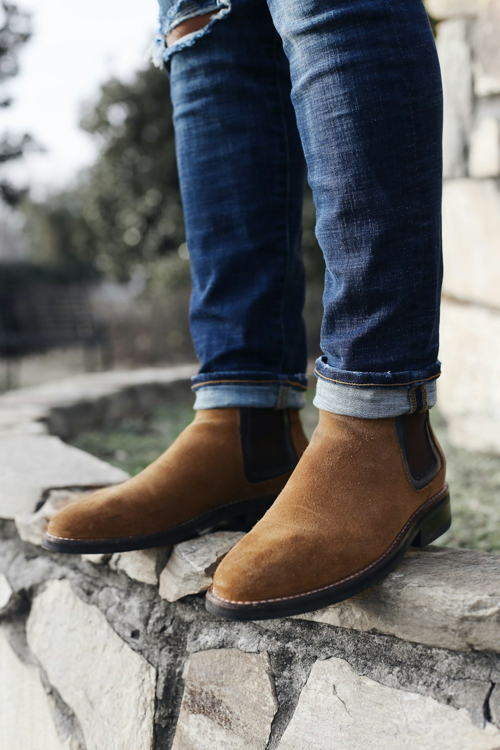 person wearing pair of brown Chelsea boots