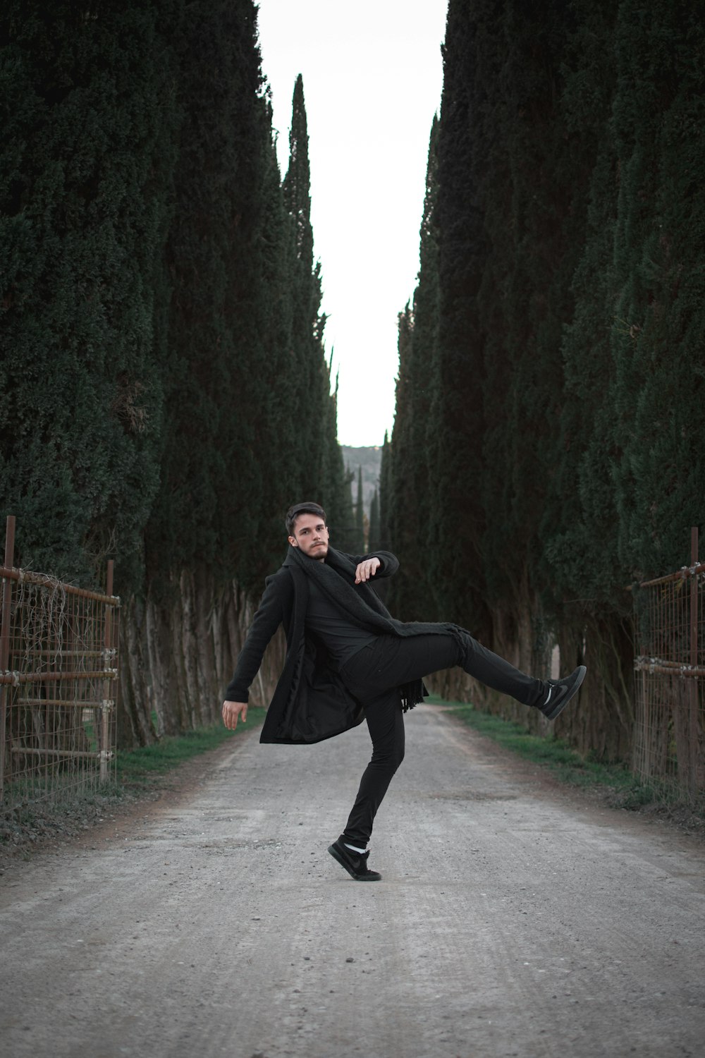 man standing in one foot in the middle of a road