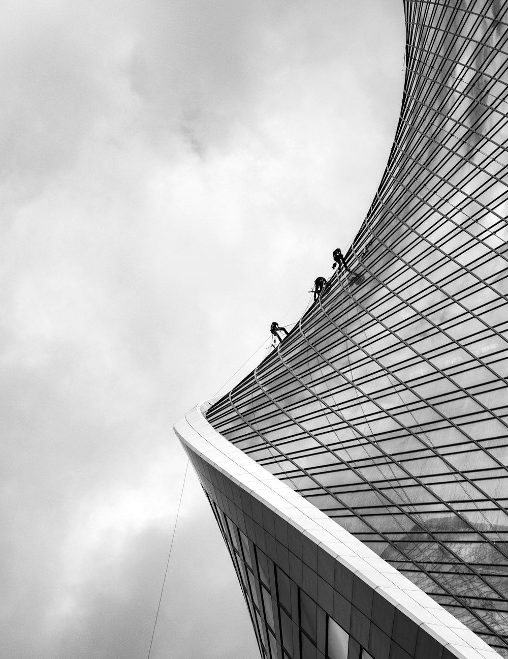 grayscale photo of men climbing on building