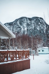 A sturdy wooden deck overlooking a snow-dusted Alaskan forest