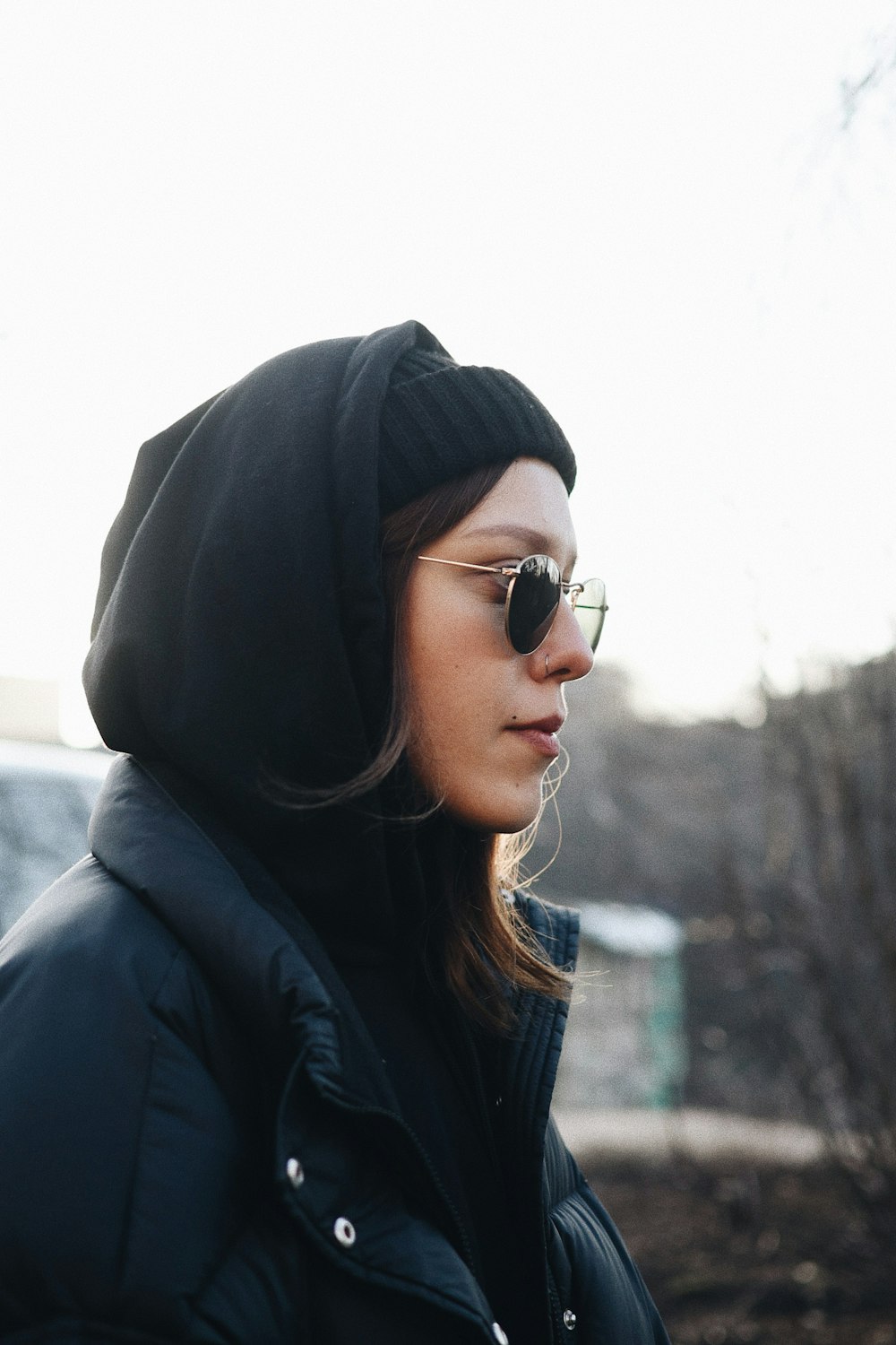 woman wearing black coat and sunglasses facing to the side